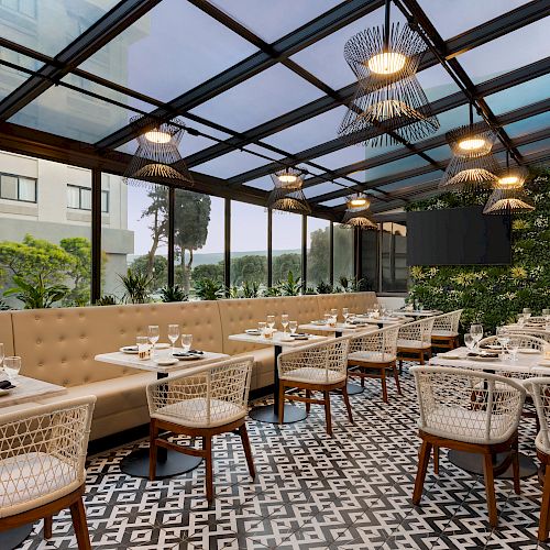 A stylish restaurant with a glass ceiling, tiled floor, and modern decor; featuring white tables, cushioned seating, and greenery on the wall.